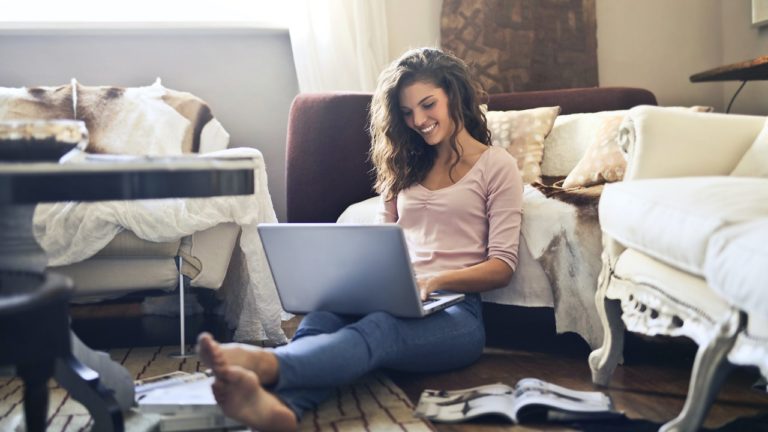 frau benutzt lächeln laptop vor sofa
