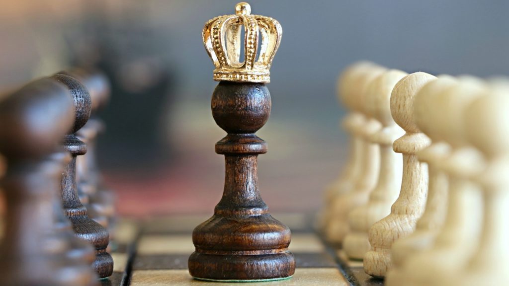 schwarze Schachfigur mit Krone auf schachbrett