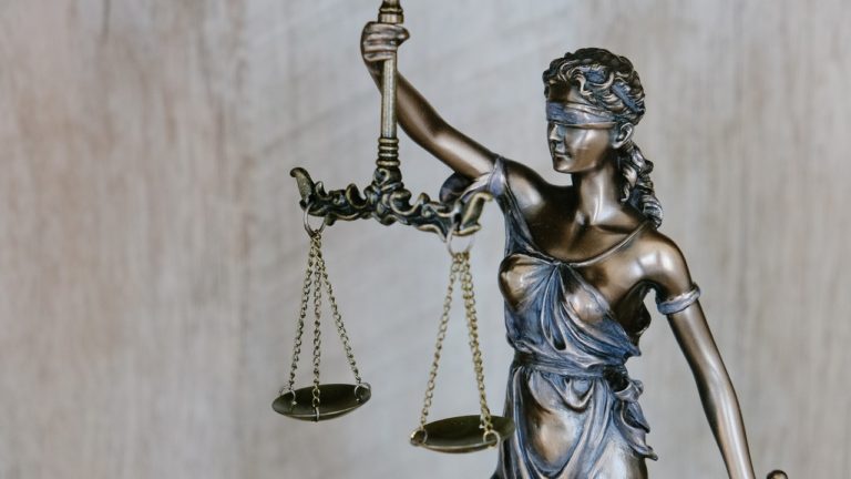 eine frau mit verbundenen augen hält eine waage