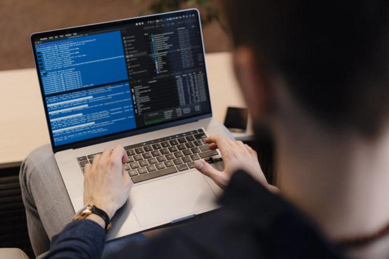Person am Laptop schreibt Code